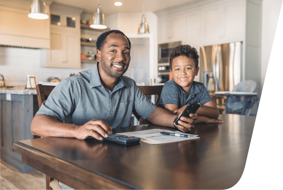 a man sitting at a table with his son, smartphone, and some documents.