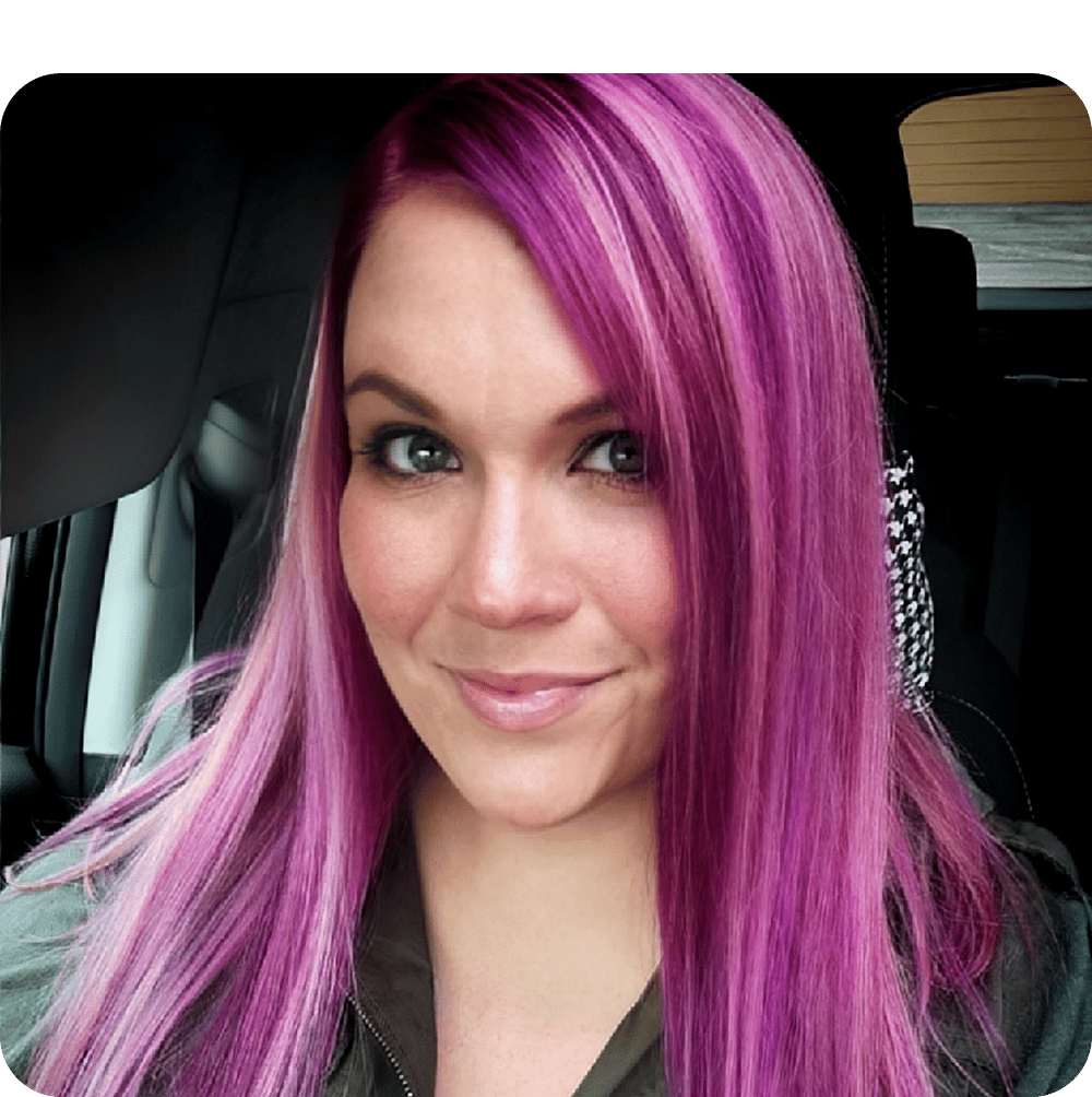 a close up of a woman with pink hair in her car